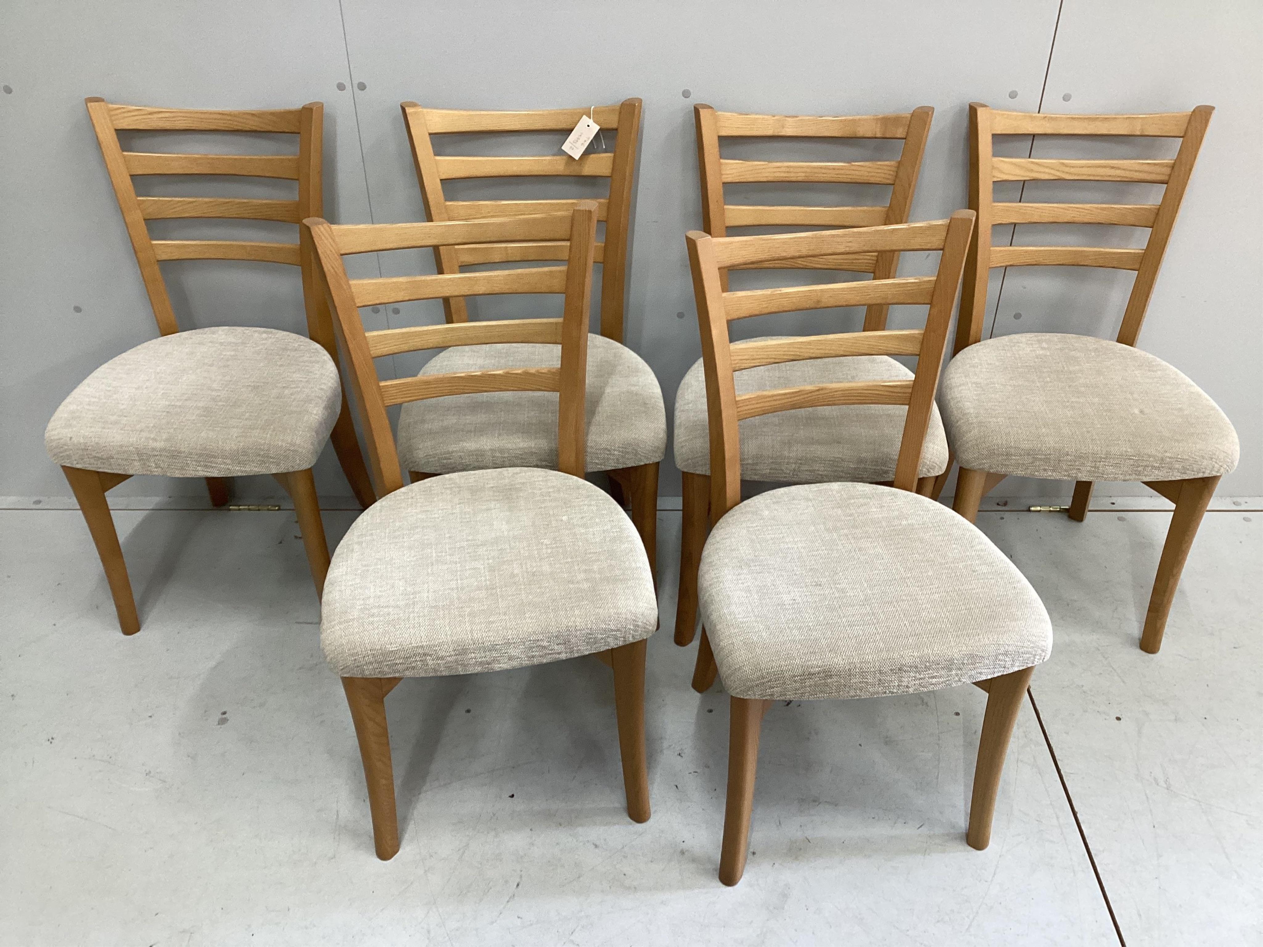 A modern Ercol elm extending dining table and six chairs, table 150cm extended, depth 89cm, height 73cm. Condition - good